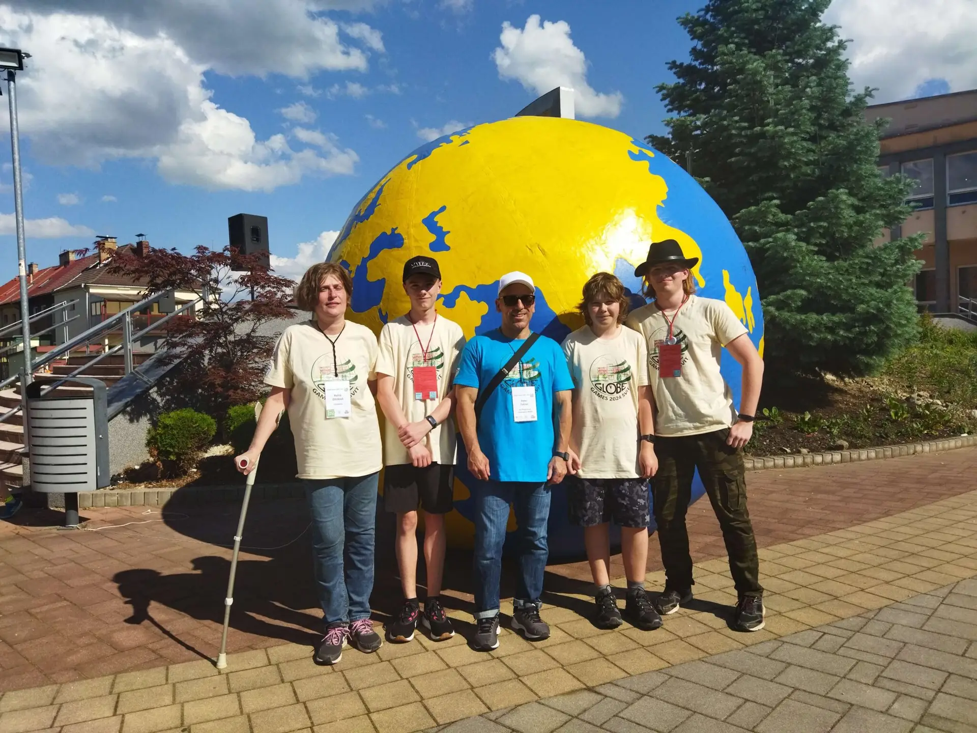 a group of people posing for a photo in front of a large globe
